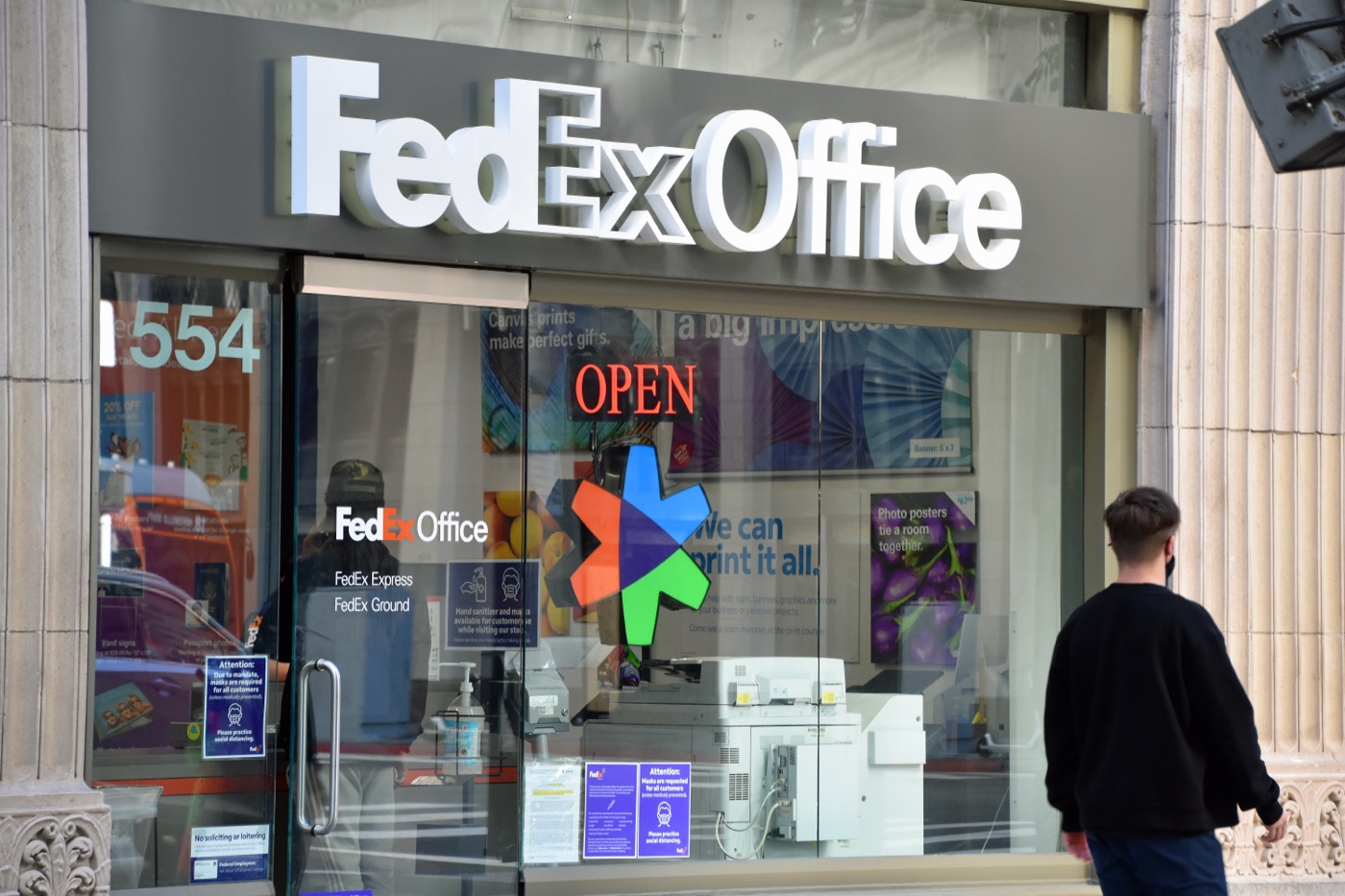 Exterior of a FedEx Office Print & Ship Center storefront with purple and orange signage.
