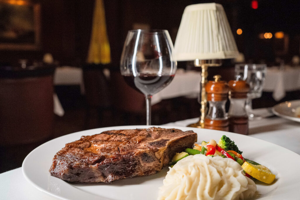 Hy's Steak House signature bone-in ribeye finished on the kiawe-wood broiler.