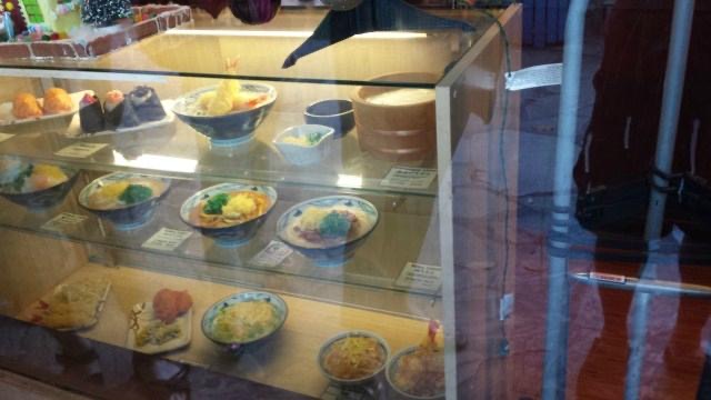 Storefront and customer line at the Marukame Udon Waikiki shop on Kuhio Avenue.