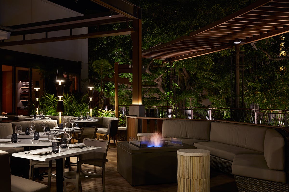 Open-air lanai patio dining at STRIPSTEAK by Michael Mina at Waikiki's International Market Place.